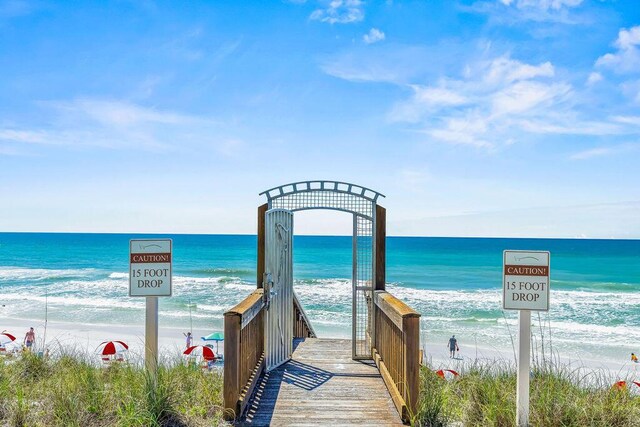 view of property's community featuring a water view and a beach view