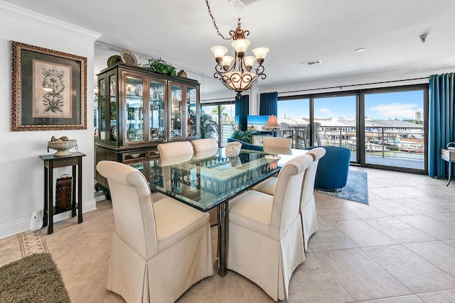 dining area with crown molding, light tile patterned floors, and a notable chandelier