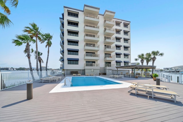 view of swimming pool featuring a deck with water view and a pergola