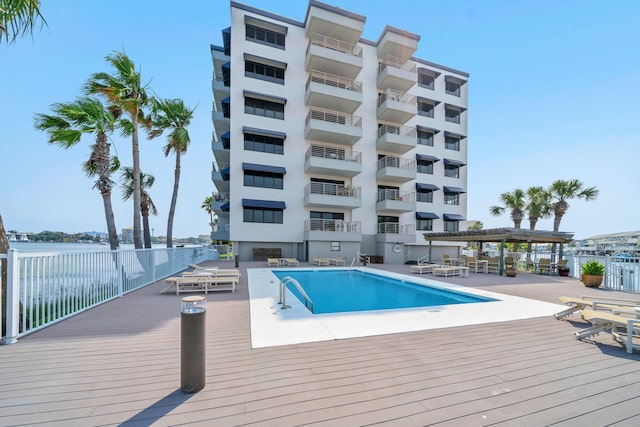 view of swimming pool featuring a deck with water view and a pergola