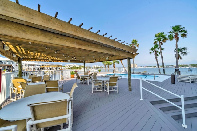 wooden deck with a water view and a community pool