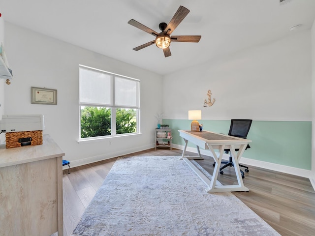 home office featuring ceiling fan and light hardwood / wood-style flooring