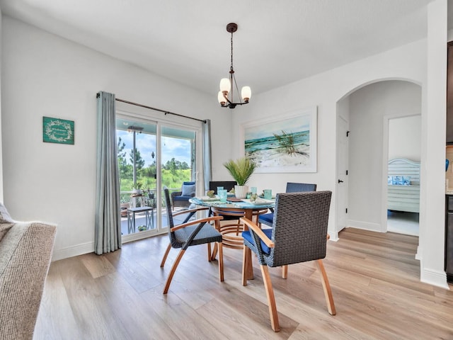 dining room featuring light wood-type flooring and a chandelier