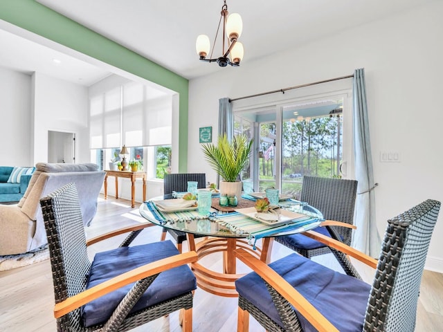 dining space featuring an inviting chandelier and light hardwood / wood-style flooring