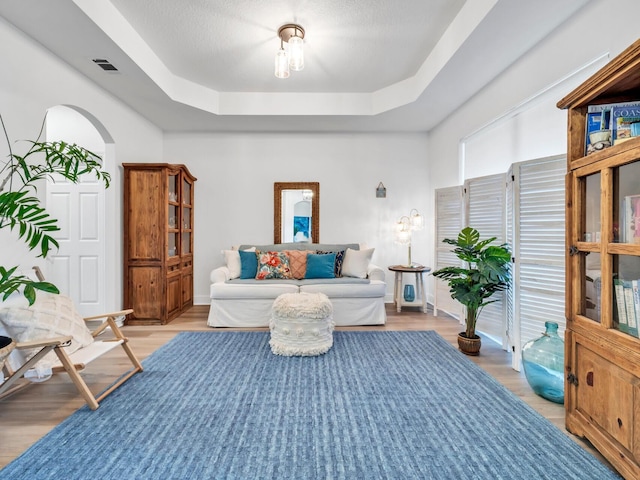 interior space featuring light hardwood / wood-style floors and a raised ceiling