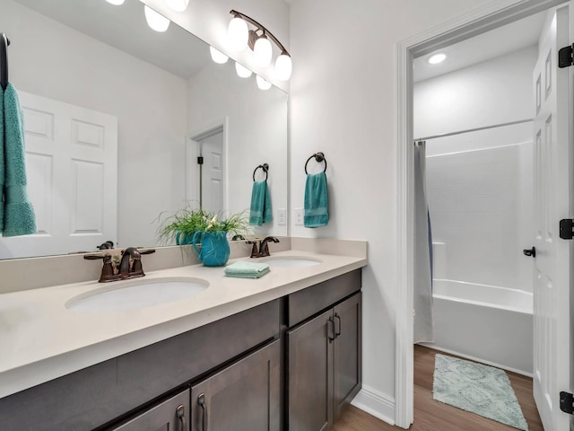 bathroom featuring shower / tub combo with curtain, dual vanity, and hardwood / wood-style flooring