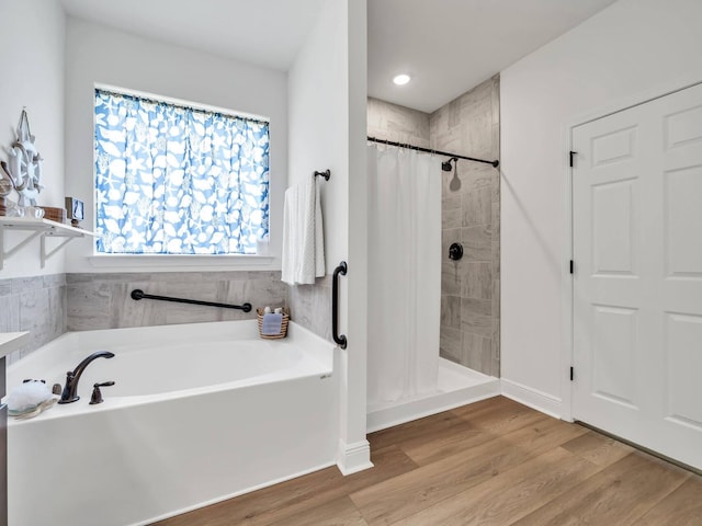 bathroom featuring hardwood / wood-style flooring and shower with separate bathtub