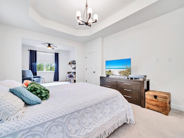 bedroom with a tray ceiling, carpet floors, and a chandelier