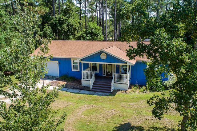 view of front facade with a garage, a front lawn, and covered porch