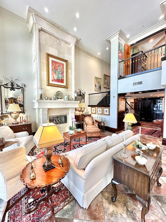 living room with a high end fireplace and ornamental molding