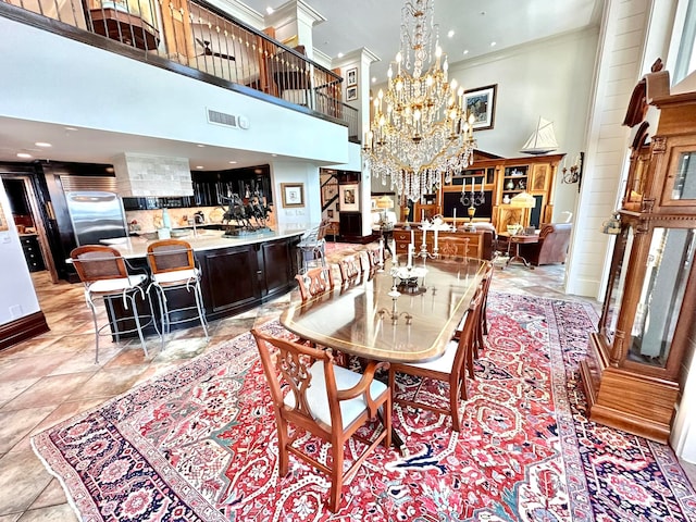 dining area featuring a towering ceiling, ornamental molding, and a chandelier