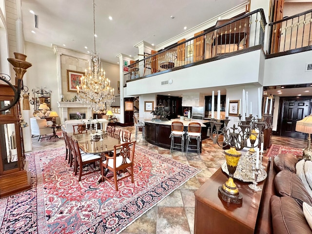 dining room with a notable chandelier, a towering ceiling, and ornamental molding