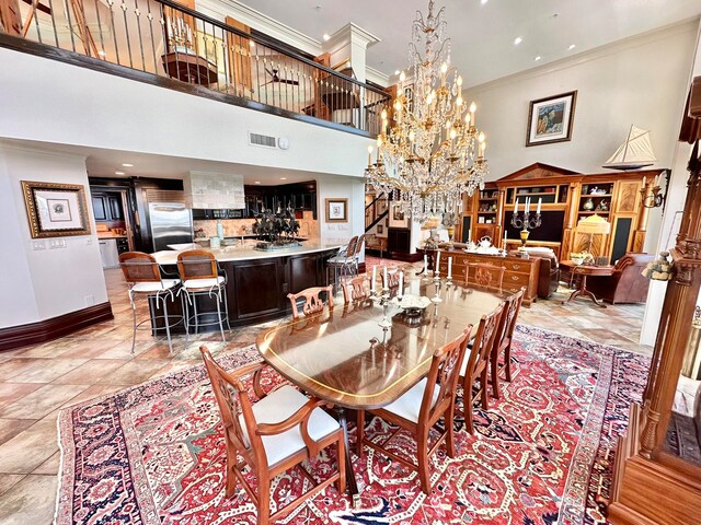 dining space featuring ornamental molding, a high ceiling, and an inviting chandelier