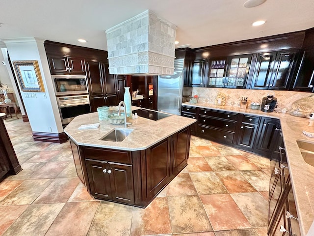 kitchen with decorative backsplash, a kitchen island with sink, ornamental molding, sink, and stainless steel appliances