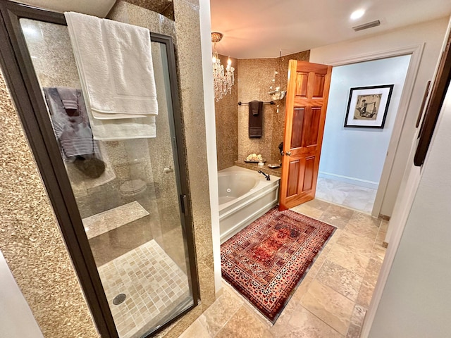 bathroom featuring a notable chandelier and independent shower and bath