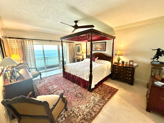 bedroom with a textured ceiling, access to exterior, a water view, and ceiling fan