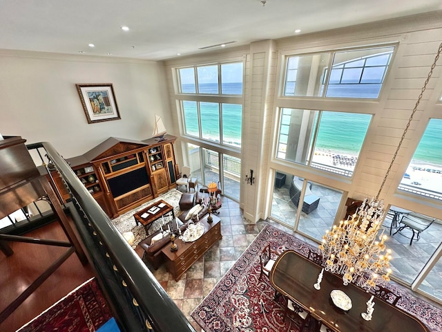 living room with a water view, crown molding, a wealth of natural light, and tile patterned flooring