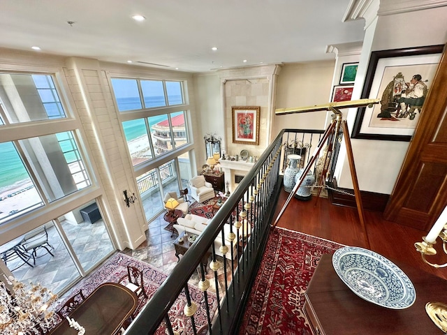 corridor with ornamental molding, hardwood / wood-style floors, and a water view