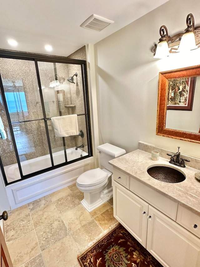 full bathroom with vanity, shower / bath combination with glass door, and toilet