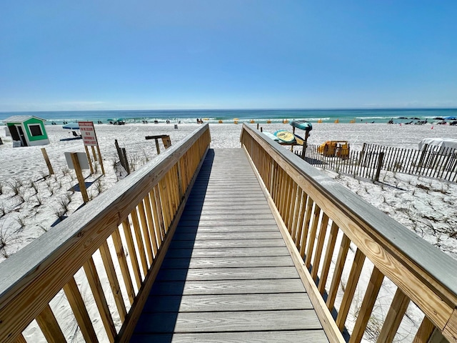 view of property's community featuring a water view and a beach view