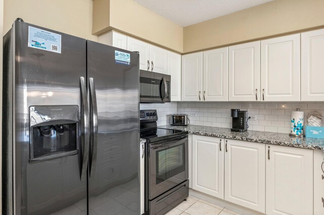 kitchen with tasteful backsplash, white cabinets, stainless steel appliances, and light stone countertops