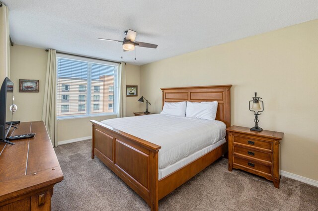 bedroom featuring a textured ceiling, carpet flooring, and ceiling fan