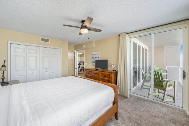 carpeted bedroom featuring access to outside, a textured ceiling, a closet, and ceiling fan