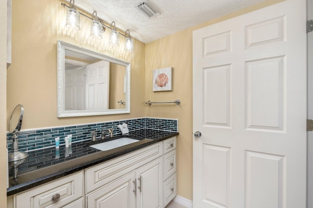 bathroom featuring vanity, a textured ceiling, and backsplash