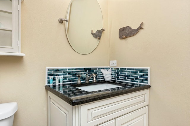 bathroom featuring tasteful backsplash, vanity, and toilet