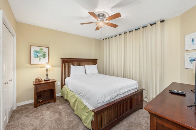 carpeted bedroom featuring ceiling fan and a closet