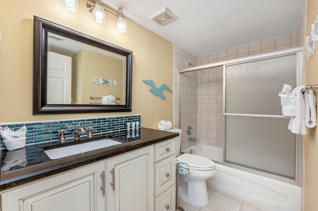 full bathroom featuring decorative backsplash, shower / bath combination with glass door, toilet, tile patterned floors, and vanity