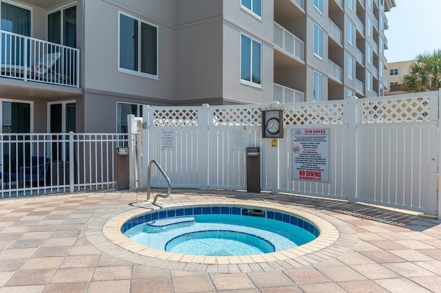 view of pool featuring a hot tub and a patio