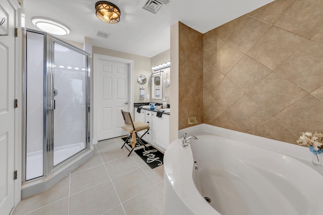 bathroom featuring tile patterned flooring, shower with separate bathtub, and vanity