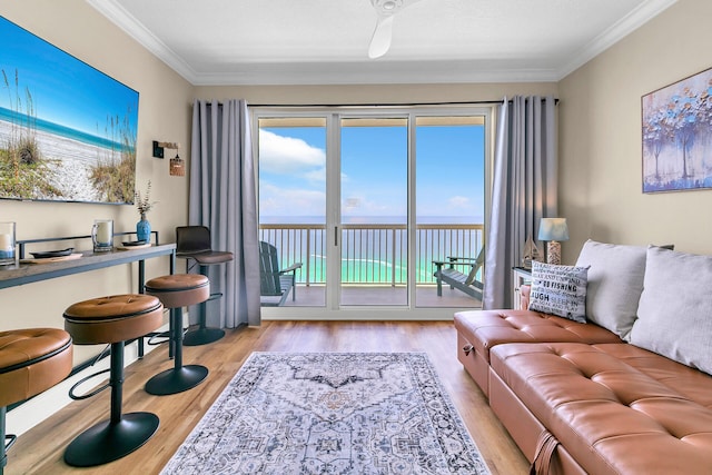 living room featuring crown molding, a water view, and light wood-type flooring