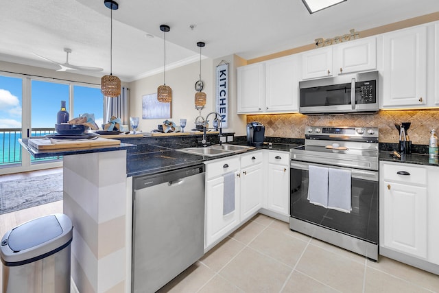 kitchen with decorative light fixtures, sink, white cabinets, kitchen peninsula, and stainless steel appliances