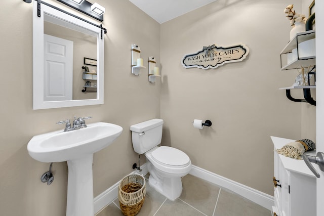 bathroom with sink, toilet, and tile patterned flooring