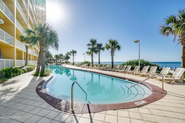 view of pool with a patio and a water view