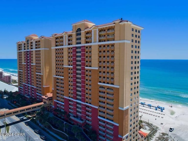 view of building exterior featuring a beach view and a water view