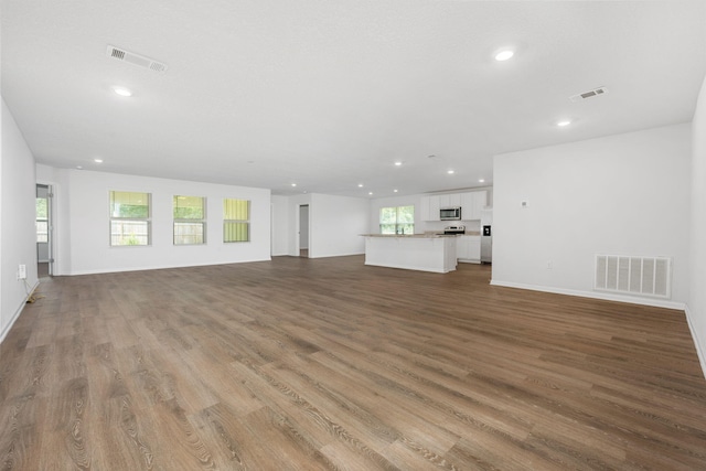 unfurnished living room with light hardwood / wood-style flooring and a healthy amount of sunlight