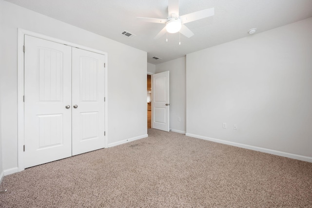 unfurnished bedroom featuring light carpet, a closet, and ceiling fan