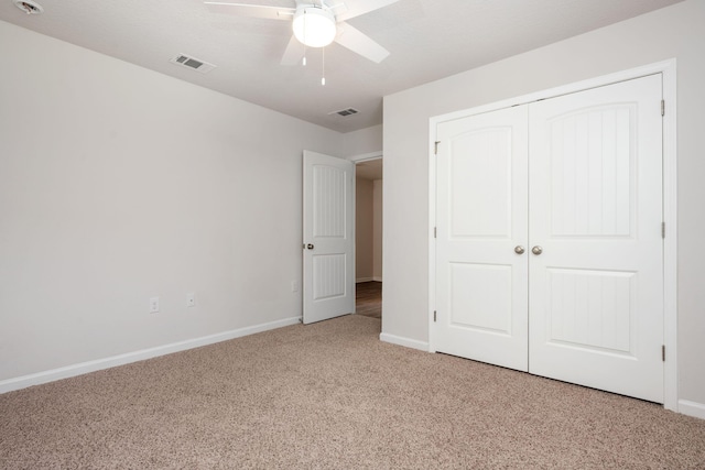 unfurnished bedroom featuring ceiling fan, a closet, and light colored carpet