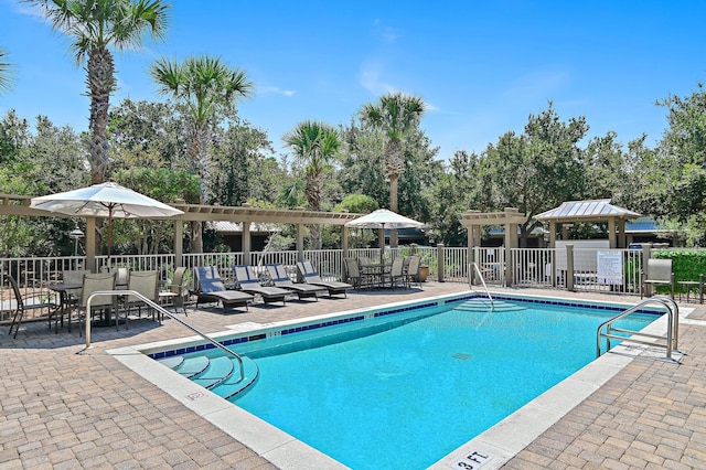 community pool featuring a patio area, fence, and a pergola