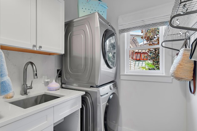 washroom featuring a sink, stacked washer and dryer, and cabinet space