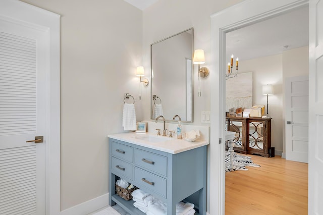 bathroom featuring wood finished floors, vanity, and baseboards