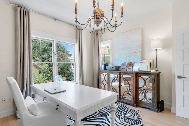 office featuring light wood-style flooring, baseboards, and a notable chandelier