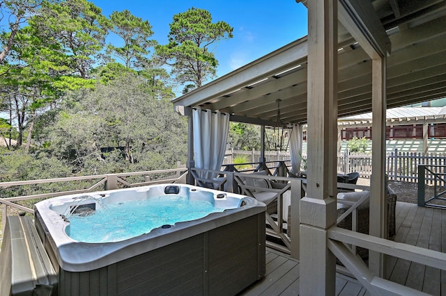 deck featuring fence and a hot tub