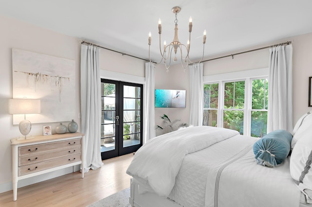 bedroom with access to outside, french doors, a notable chandelier, and light wood finished floors