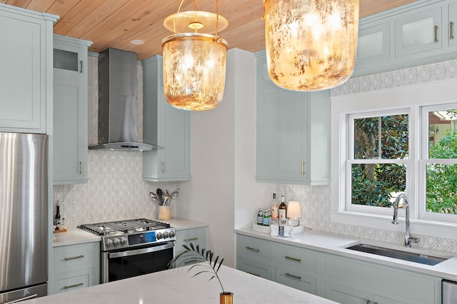 kitchen with stainless steel appliances, glass insert cabinets, a sink, wall chimney range hood, and wooden ceiling