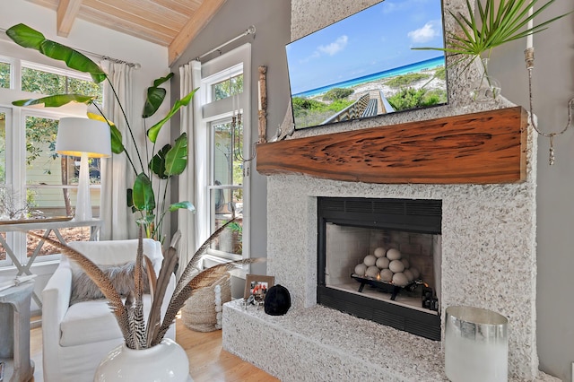 interior space featuring lofted ceiling, a premium fireplace, wooden ceiling, and wood finished floors