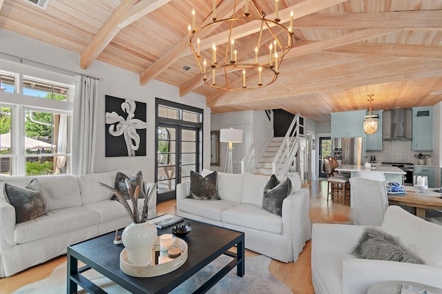 living room featuring light wood-type flooring, an inviting chandelier, wood ceiling, and stairway